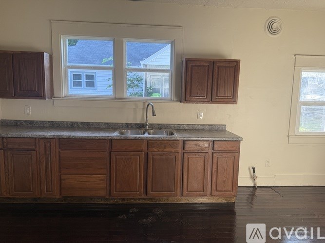 A kitchen with wooden cabinets and a marble countertop.