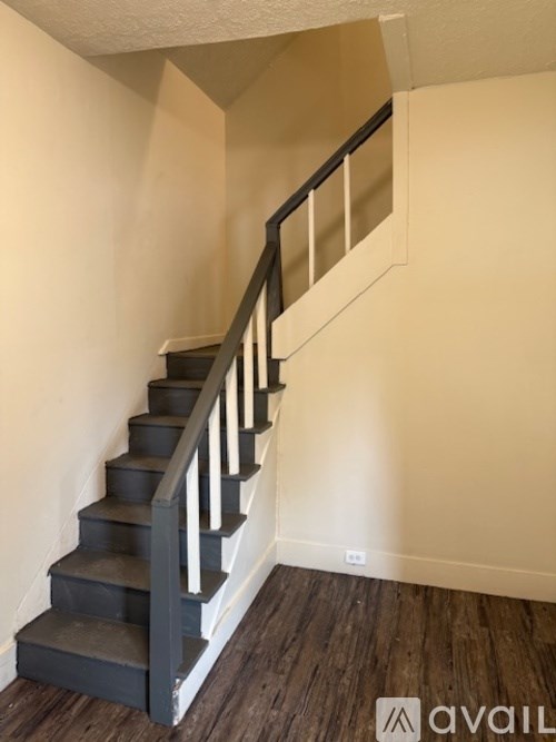 A staircase with a wooden handrail and steps leading up to a landing.