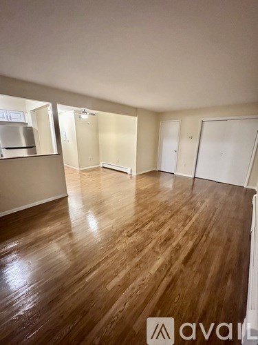 A room with wooden flooring and white walls.