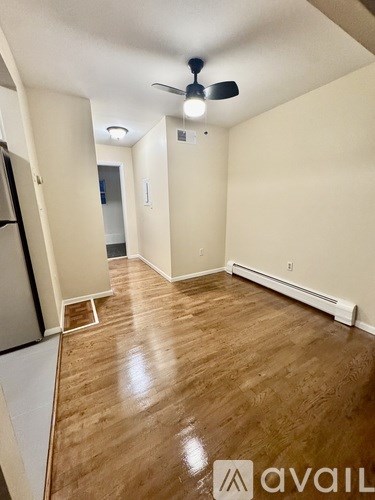 A room with a ceiling fan and wooden flooring.