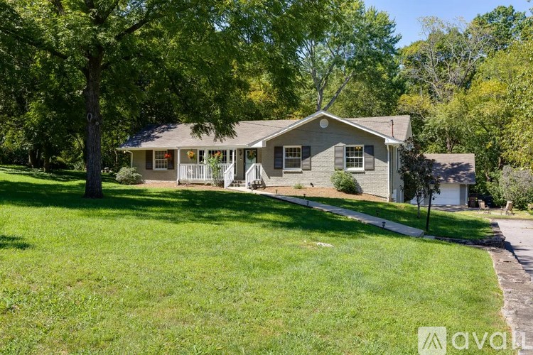 A house with a lawn and trees in the background.