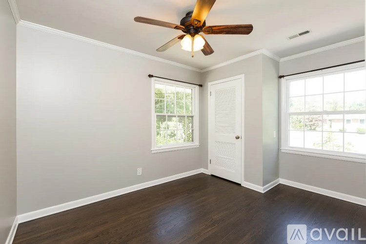 A room with a ceiling fan and sliding glass doors.