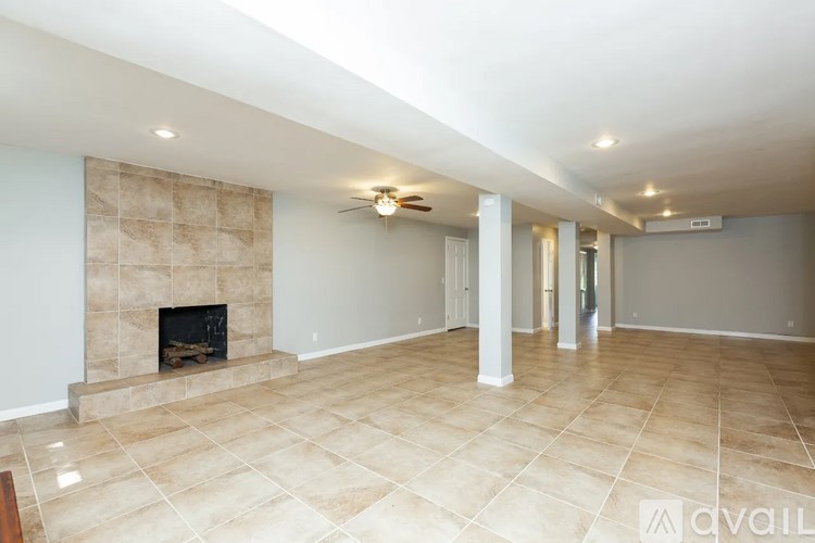 A spacious living room with a fireplace and tiled flooring.