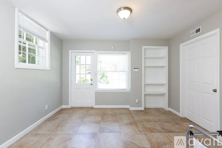 A room with a tiled floor and a window with blinds.