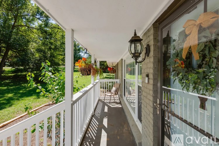 A white porch with a white railing and a hanging light.