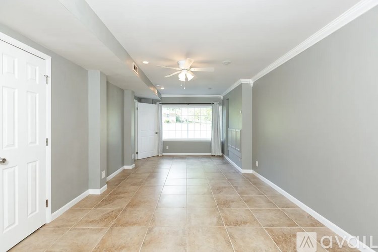 A long hallway with tiled floors and white walls.