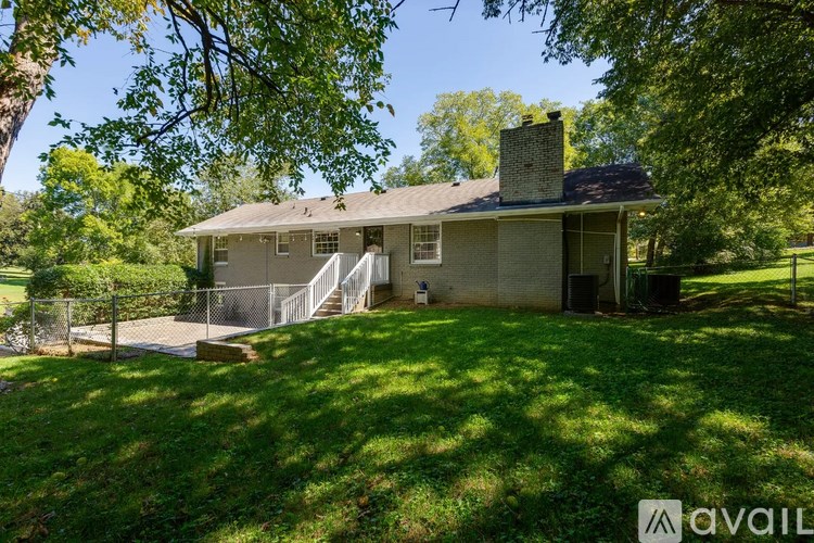 A house with a green lawn and trees around it.