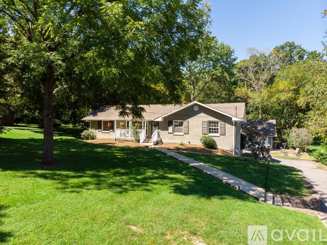 A house with a lawn and trees in front of it.