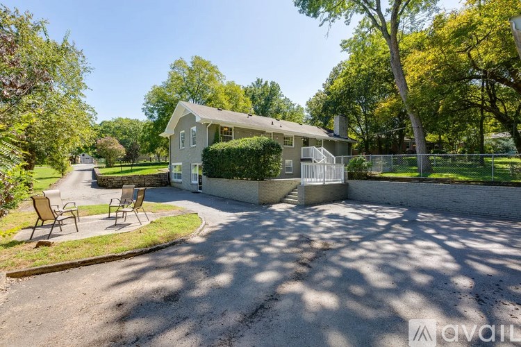 A house with a white fence and a driveway in front.