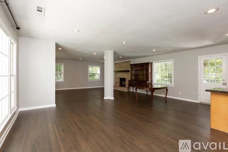 A spacious living room with wood flooring and a large window.