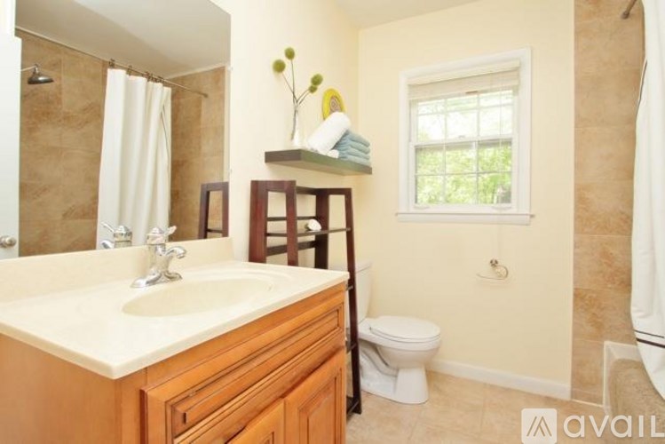 A bathroom with a toilet, sink, and window.