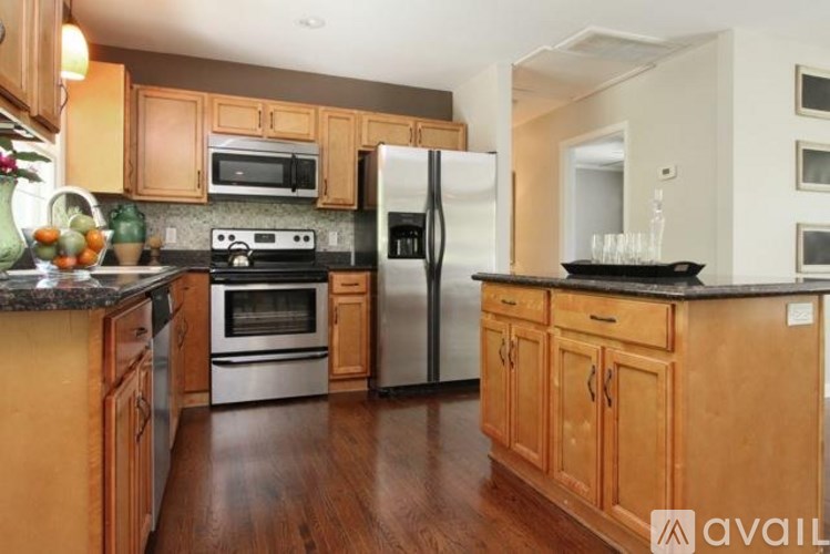 A kitchen with wooden cabinets and a black countertop.