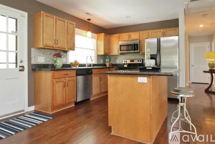 A kitchen with wooden cabinets and a black countertop.