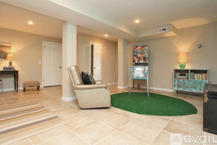 A living room with a green rug and a chair.