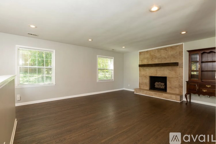 A spacious living room with a fireplace and wooden floors.