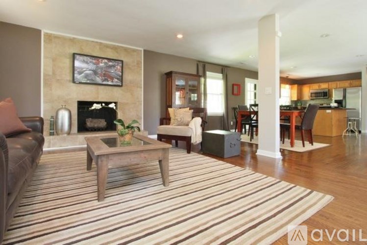 A living room with a fireplace and a painting on the wall.