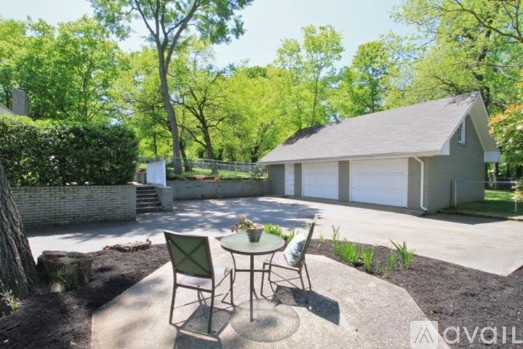 A backyard with a patio table and chairs.