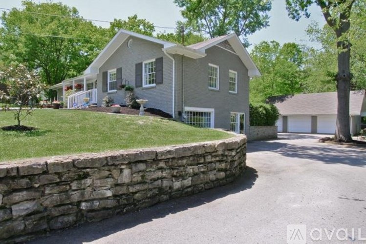 A house with a stone wall in front of it.