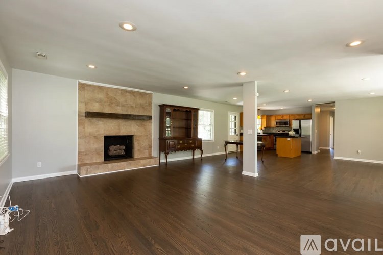 A spacious living room with a fireplace and hardwood floors.