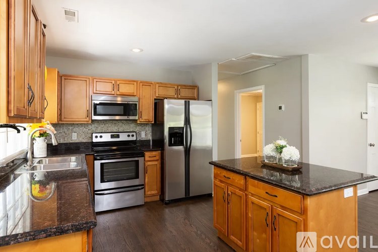 A kitchen with wooden cabinets and a black countertop.