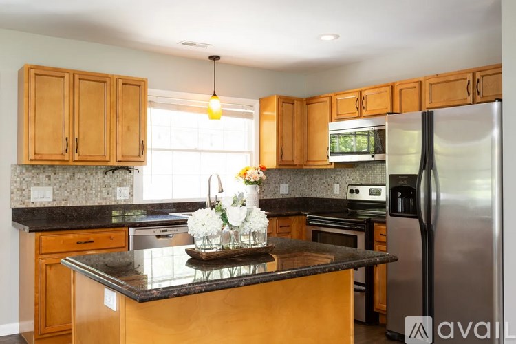 A kitchen with wooden cabinets and a granite countertop.