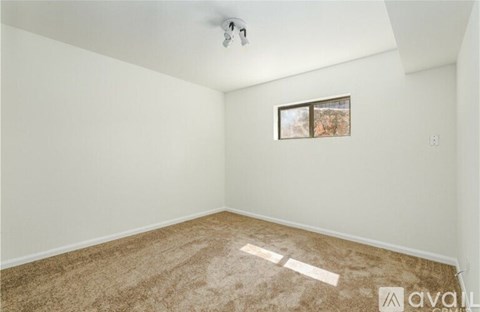 A room with a carpeted floor and a framed picture on the wall.
