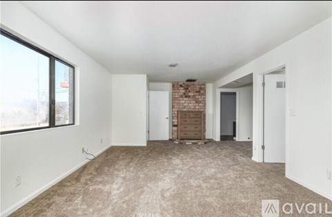 A room with a carpeted floor and a brick wall in the background.
