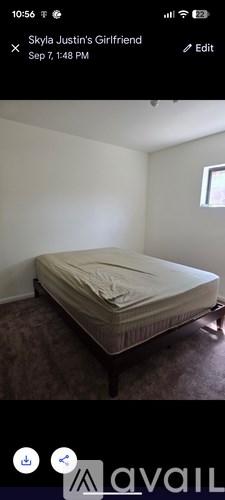 A bed with a white sheet is in a room with white walls.