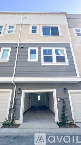 A grey building with a white garage door and windows.
