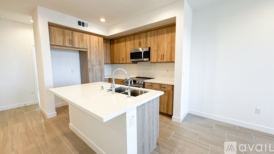 A kitchen with a white countertop and wooden cabinets.