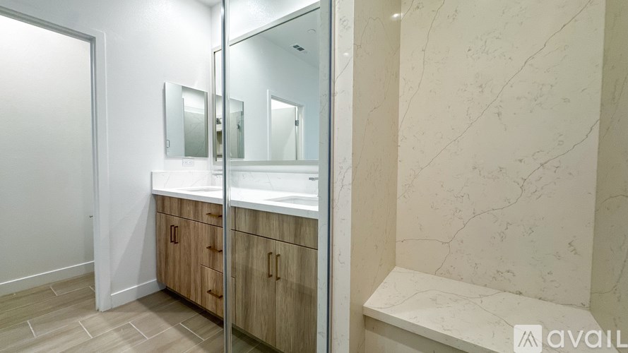 A bathroom with a marble wall and a vanity with a mirror.