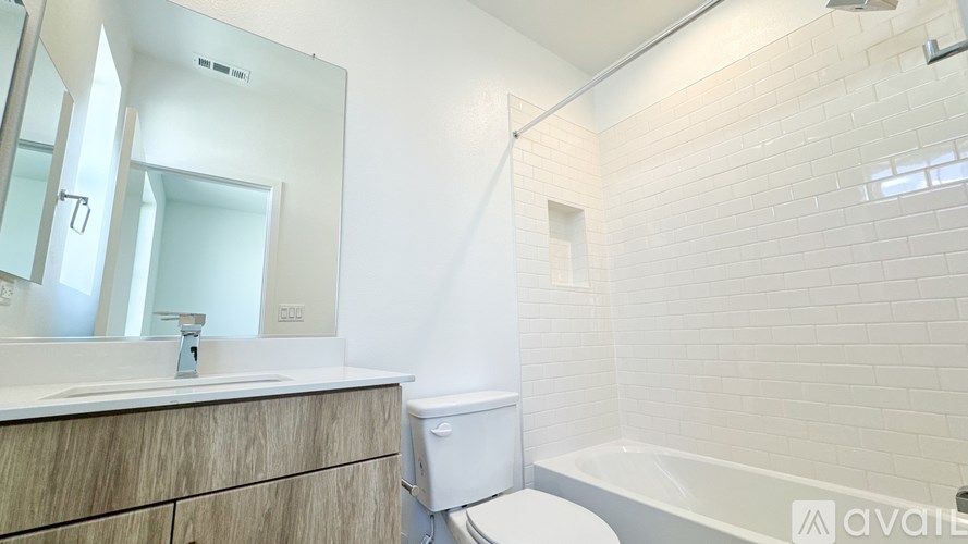 A white bathroom with a tub, sink, and toilet.