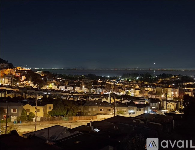 A nighttime view of a residential area with houses and streetlights.
