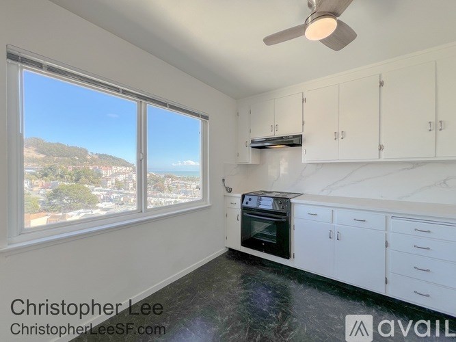 A kitchen with white cabinets and a black countertop.