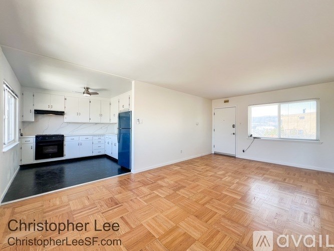 A kitchen with white cabinets and a black countertop.