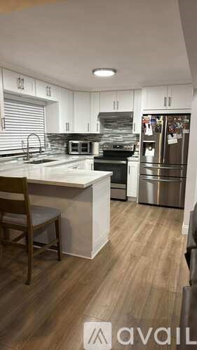 A modern kitchen with a white island and stainless steel appliances.
