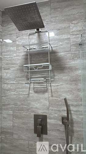 A shower with a glass door and a metal rack.