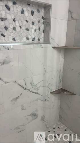 A white marble bathroom with a window.