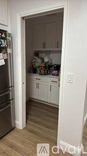 A kitchen with a refrigerator and cabinets.