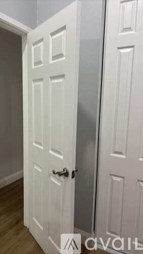 A white door with a black handle is in a room.