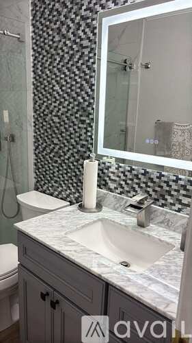 A bathroom with a sink, toilet and mirror.