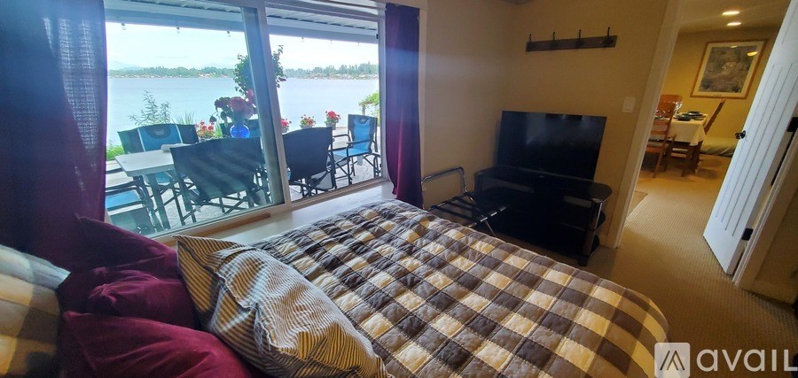 A bedroom with a large bed and a view of the water.