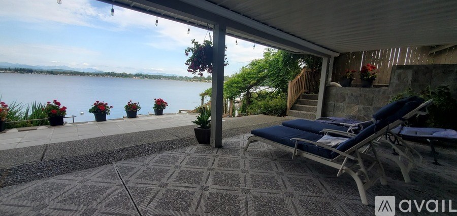 A patio with chairs and a view of a lake.