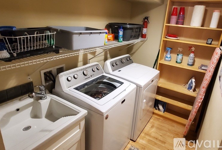 A small kitchen with a white sink, a white stove, and a white dishwasher.