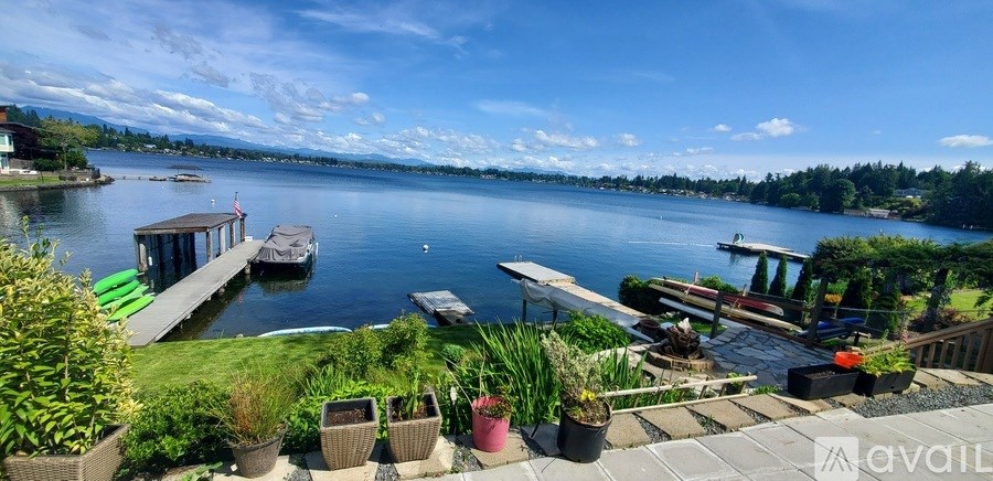 A serene lakeside view with a dock and boats.