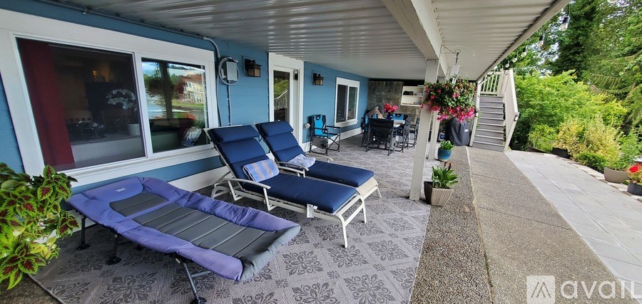 A patio with a blue cushioned chair and a blue mattress.