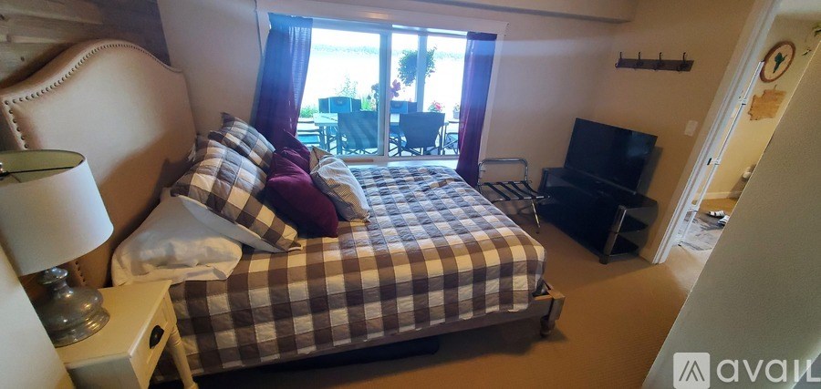 A bedroom with a bed, a couch, and a television.