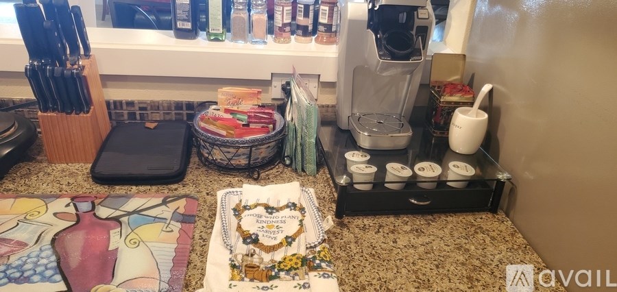 A kitchen counter with a knife block, cutting board, and various kitchen items.