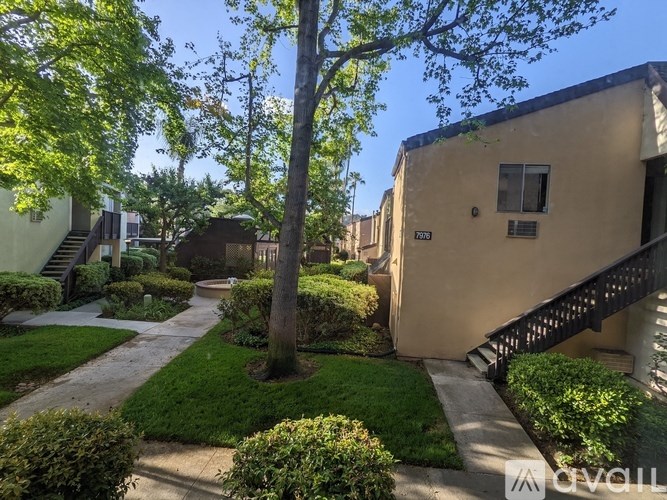 A tree in a yard with a building in the background.