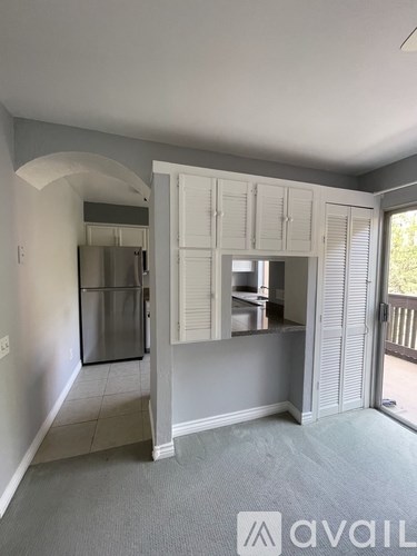 A kitchen with a refrigerator, cabinets, and a countertop.